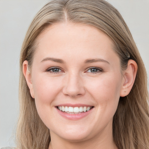 Joyful white young-adult female with long  brown hair and grey eyes