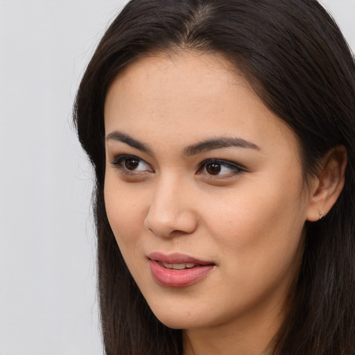 Joyful latino young-adult female with long  brown hair and brown eyes