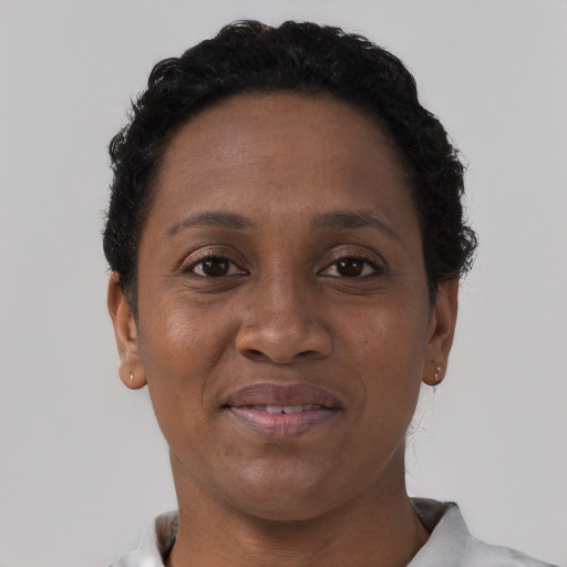 Joyful black adult female with short  black hair and brown eyes