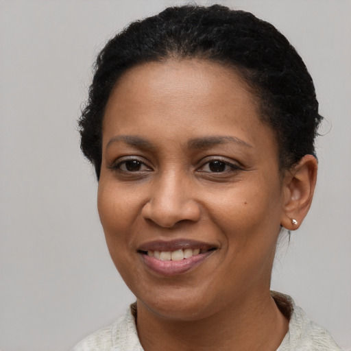 Joyful black young-adult female with short  brown hair and brown eyes