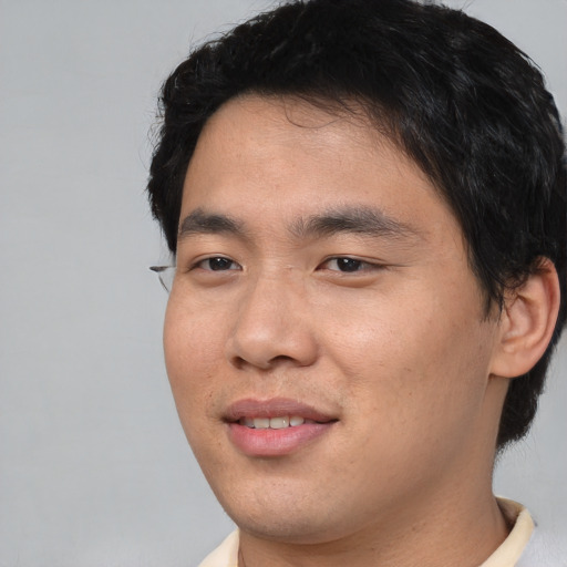 Joyful asian young-adult male with short  black hair and brown eyes