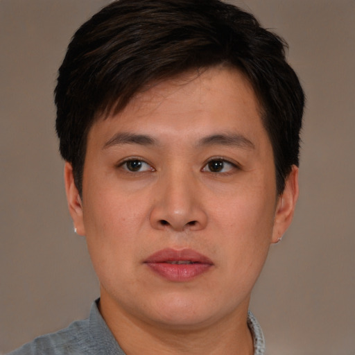 Joyful asian young-adult male with short  brown hair and brown eyes
