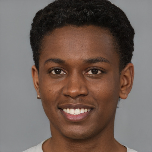 Joyful black young-adult male with short  brown hair and brown eyes