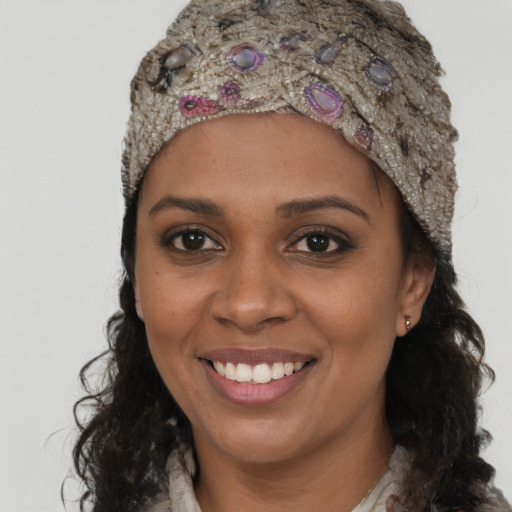 Joyful black young-adult female with long  brown hair and brown eyes