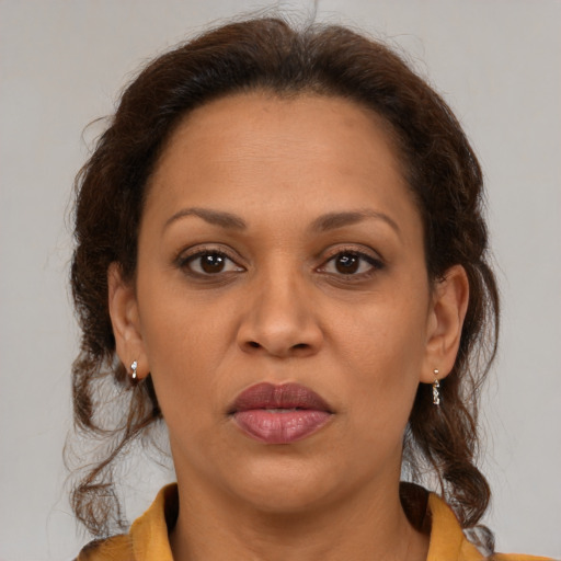 Joyful latino adult female with medium  brown hair and brown eyes