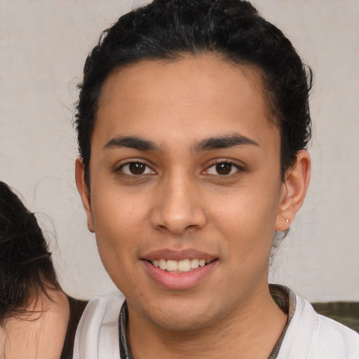 Joyful latino young-adult female with short  brown hair and brown eyes