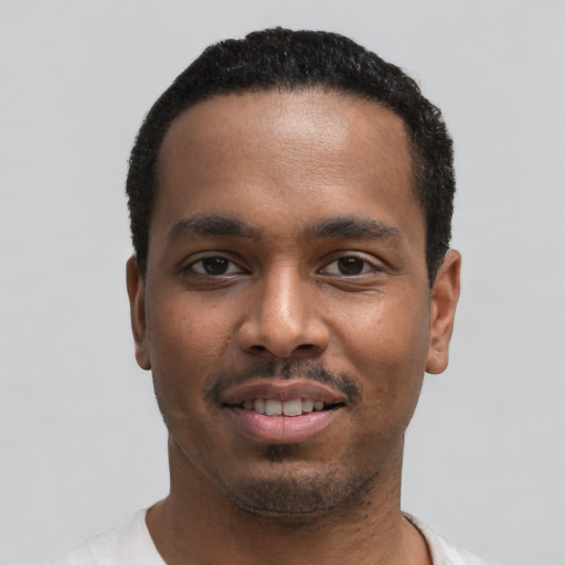 Joyful black young-adult male with short  black hair and brown eyes