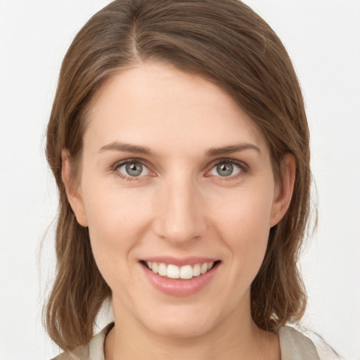 Joyful white young-adult female with medium  brown hair and grey eyes