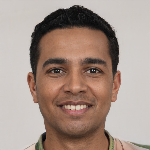 Joyful latino young-adult male with short  black hair and brown eyes