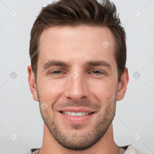 Joyful white young-adult male with short  brown hair and grey eyes