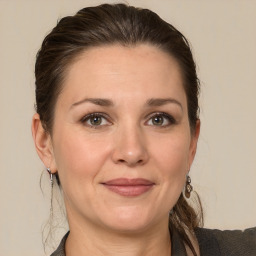 Joyful white young-adult female with medium  brown hair and grey eyes