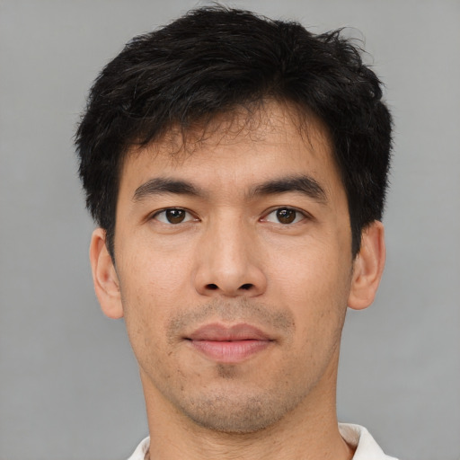 Joyful asian young-adult male with short  brown hair and brown eyes