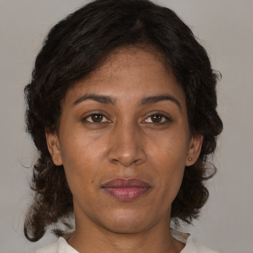 Joyful latino adult female with medium  brown hair and brown eyes