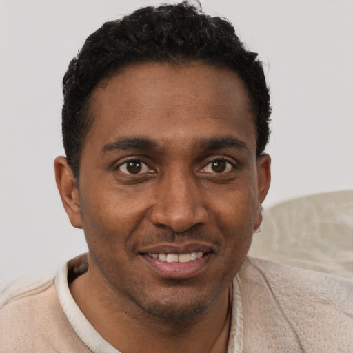 Joyful black young-adult male with short  brown hair and brown eyes