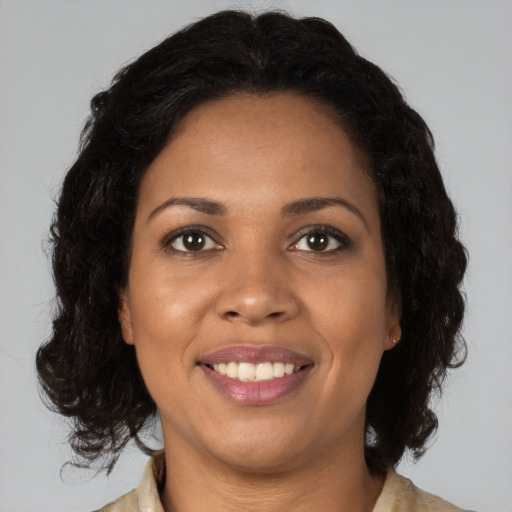 Joyful black adult female with medium  brown hair and brown eyes