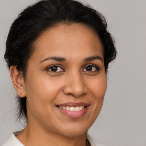 Joyful latino adult female with short  brown hair and brown eyes