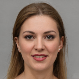 Joyful white young-adult female with long  brown hair and grey eyes