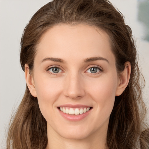 Joyful white young-adult female with long  brown hair and grey eyes