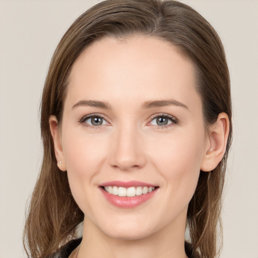 Joyful white young-adult female with medium  brown hair and grey eyes