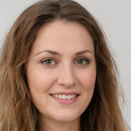 Joyful white young-adult female with long  brown hair and green eyes