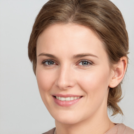 Joyful white young-adult female with medium  brown hair and grey eyes