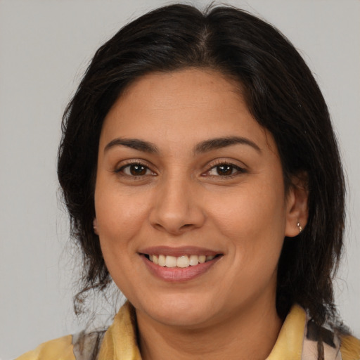 Joyful latino young-adult female with medium  brown hair and brown eyes