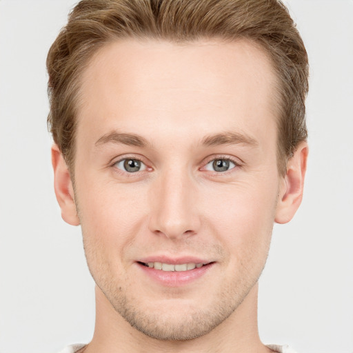 Joyful white young-adult male with short  brown hair and grey eyes