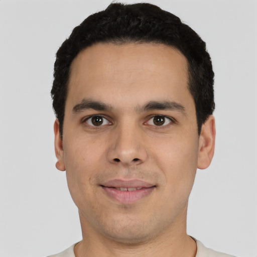Joyful latino young-adult male with short  black hair and brown eyes