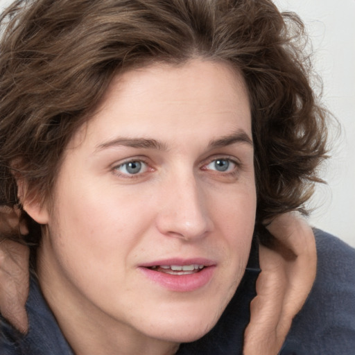 Joyful white young-adult female with medium  brown hair and blue eyes