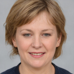 Joyful white adult female with medium  brown hair and grey eyes