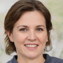 Joyful white adult female with medium  brown hair and grey eyes