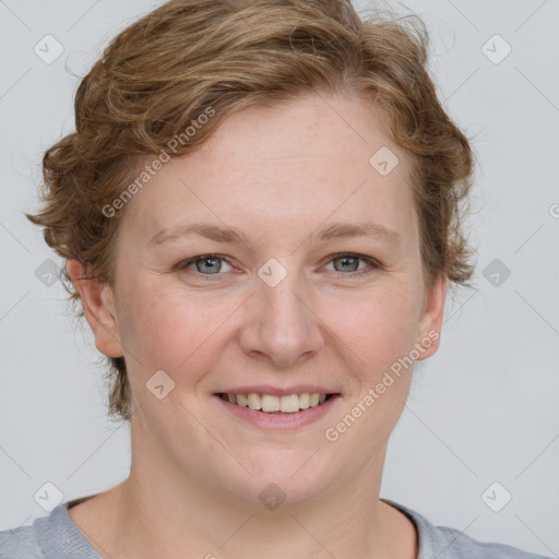 Joyful white young-adult female with short  brown hair and blue eyes