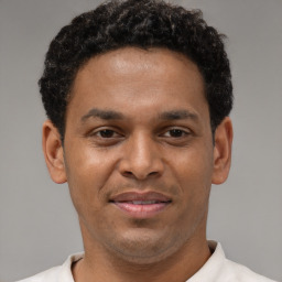 Joyful latino young-adult male with short  brown hair and brown eyes