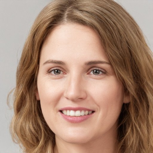 Joyful white young-adult female with long  brown hair and green eyes