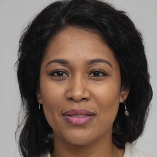 Joyful black adult female with long  brown hair and brown eyes