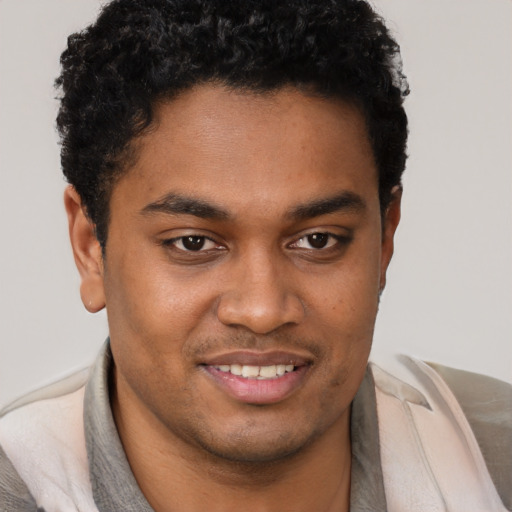 Joyful black young-adult male with short  brown hair and brown eyes