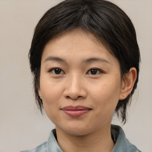Joyful asian young-adult female with medium  brown hair and brown eyes