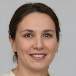 Joyful white adult female with medium  brown hair and grey eyes