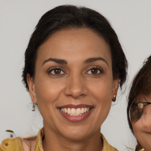 Joyful latino young-adult female with medium  brown hair and brown eyes