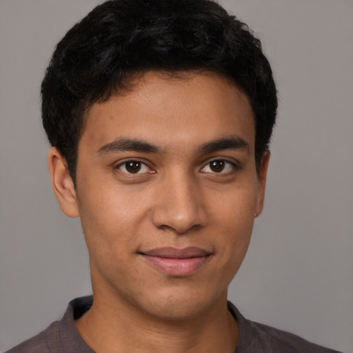 Joyful latino young-adult male with short  brown hair and brown eyes