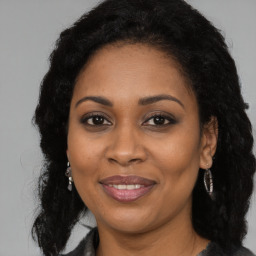 Joyful black adult female with long  brown hair and brown eyes