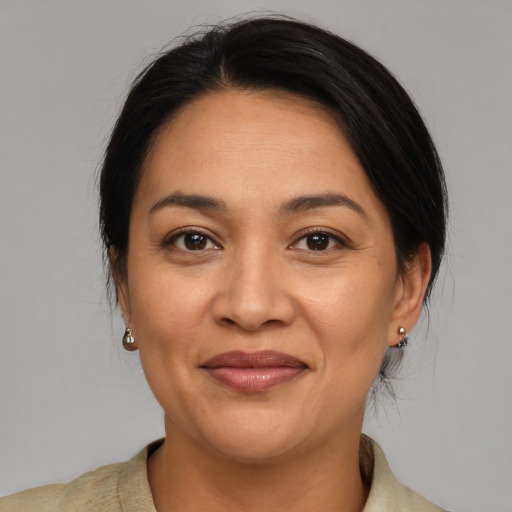 Joyful latino adult female with medium  brown hair and brown eyes