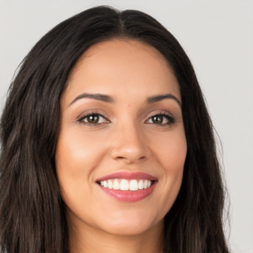 Joyful latino young-adult female with long  brown hair and brown eyes