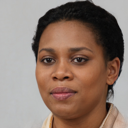 Joyful black young-adult female with short  brown hair and brown eyes