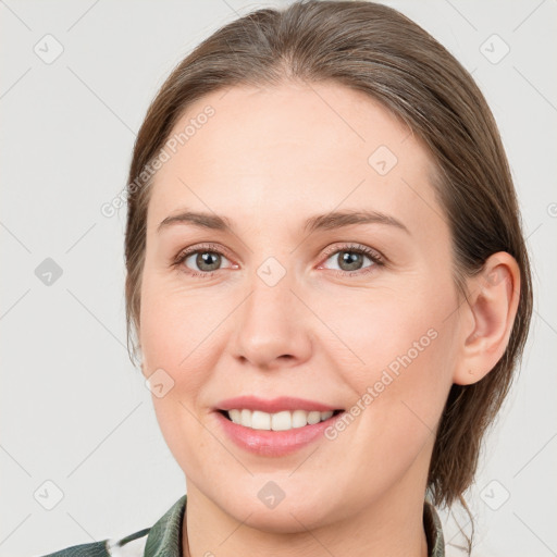 Joyful white young-adult female with medium  brown hair and grey eyes