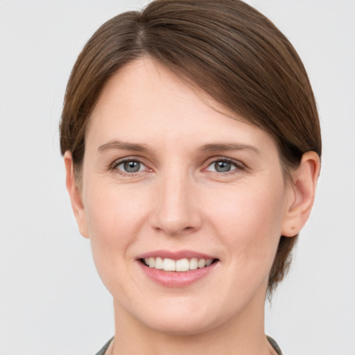 Joyful white young-adult female with short  brown hair and grey eyes