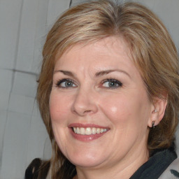 Joyful white adult female with medium  brown hair and blue eyes