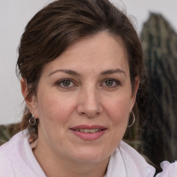 Joyful white adult female with medium  brown hair and grey eyes