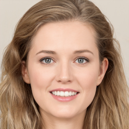 Joyful white young-adult female with long  brown hair and green eyes