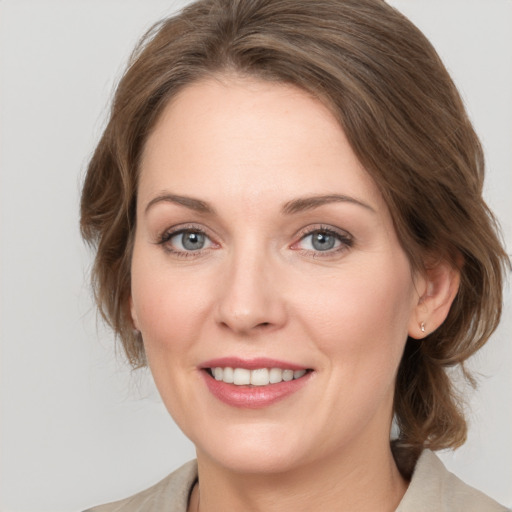 Joyful white young-adult female with medium  brown hair and grey eyes